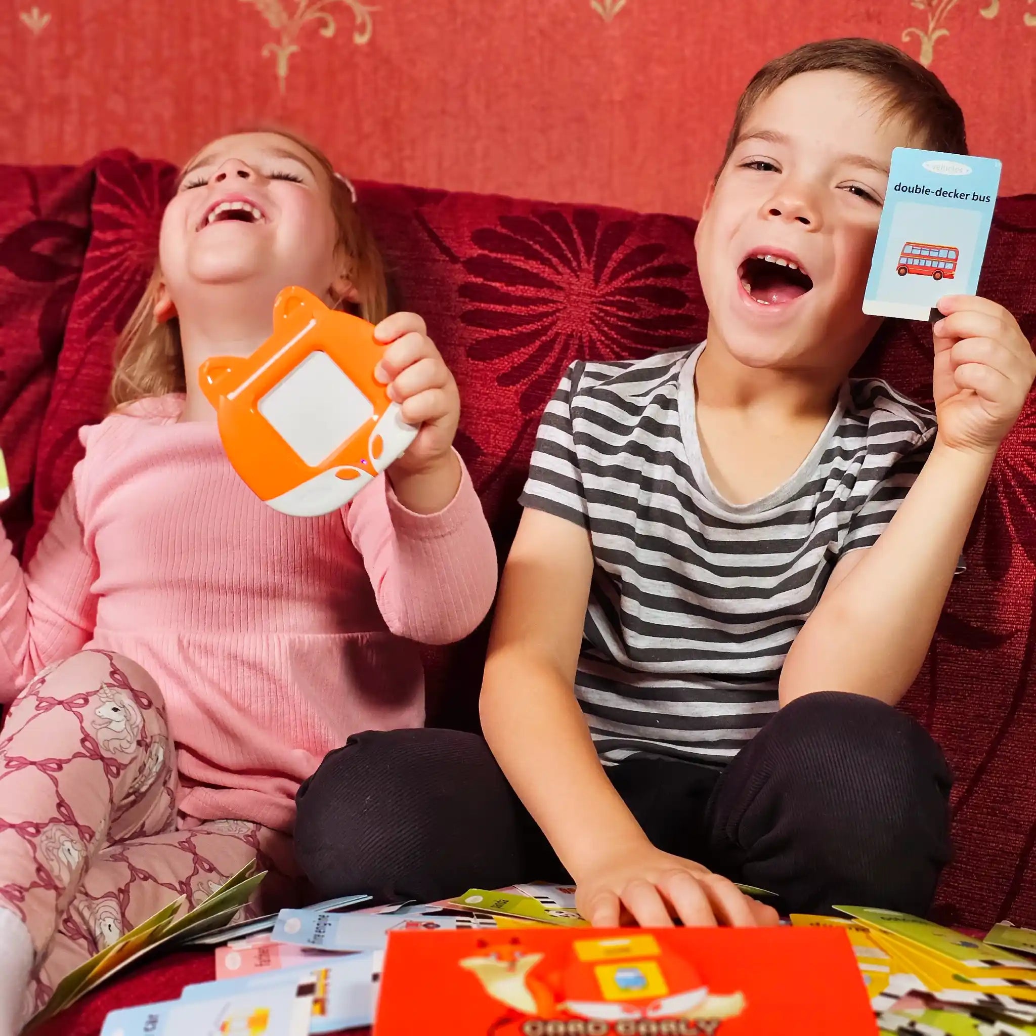 Two young children enjoying a screen-free early learning flashcard device while learning words and pictures
